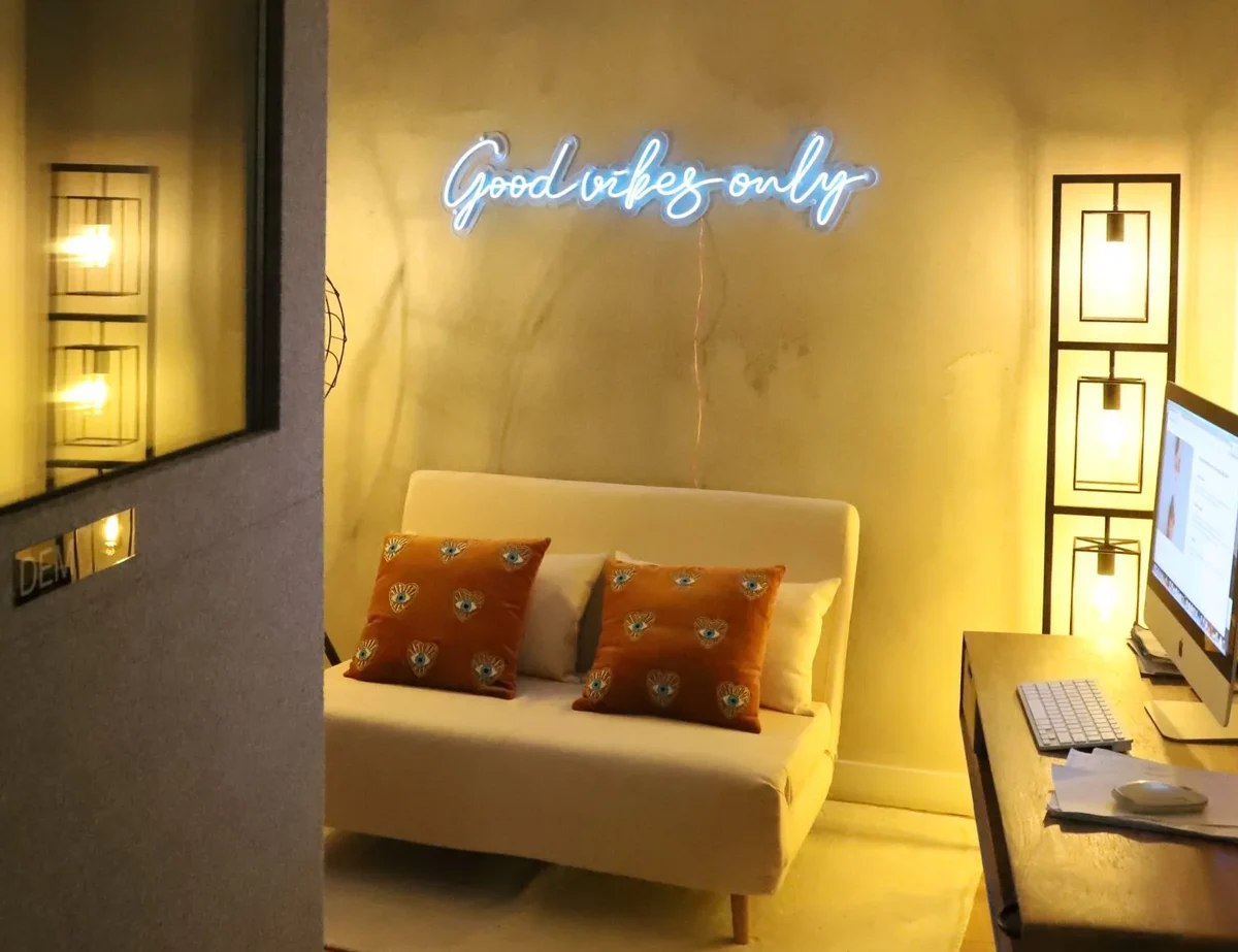 Le coin détente de la cabine voix off, néon « Good vibes only »